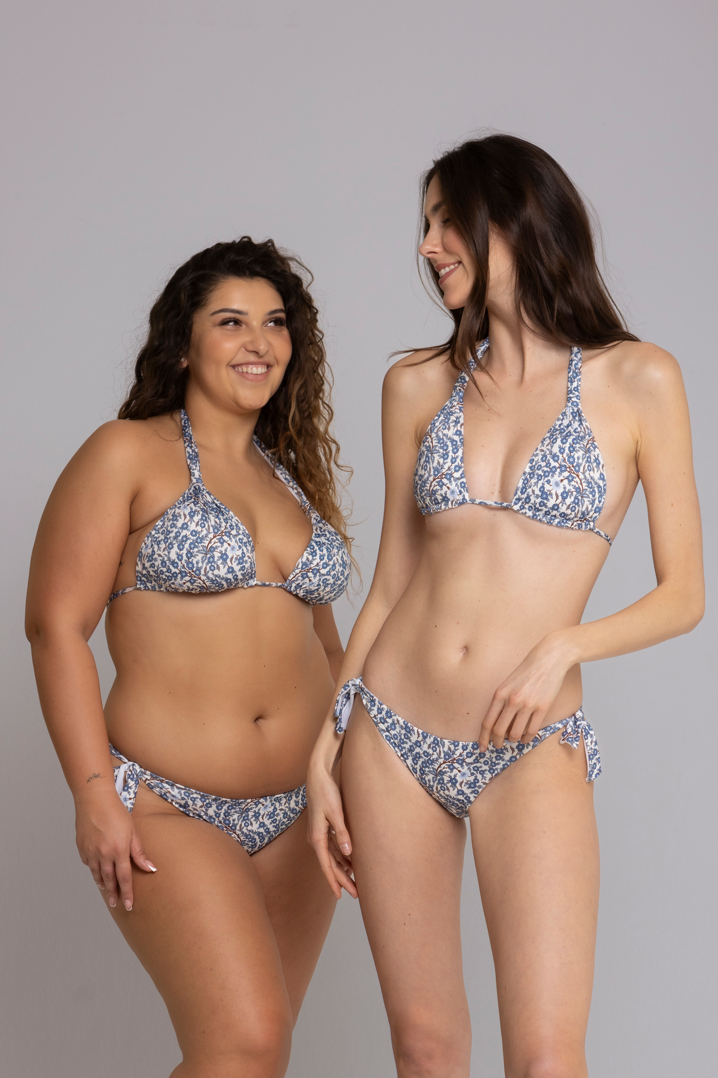 Two models wearing Megan Floral Light Blue Triangle Bikini Set front view — one in size small, one in size large