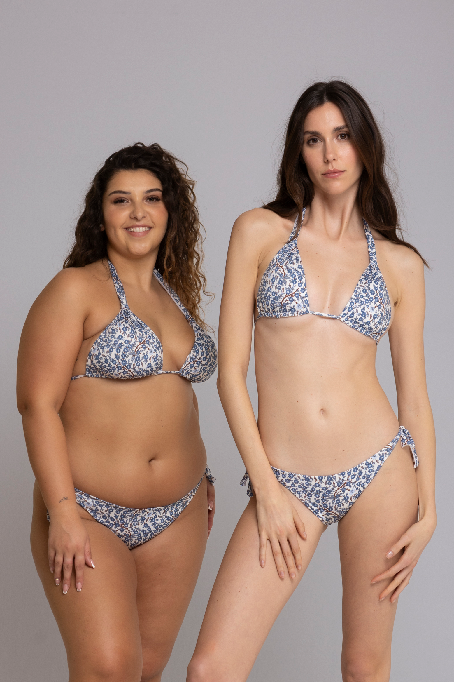 Two models wearing Megan Floral Light Blue Triangle Bikini Set front view — one in size small, one in size large