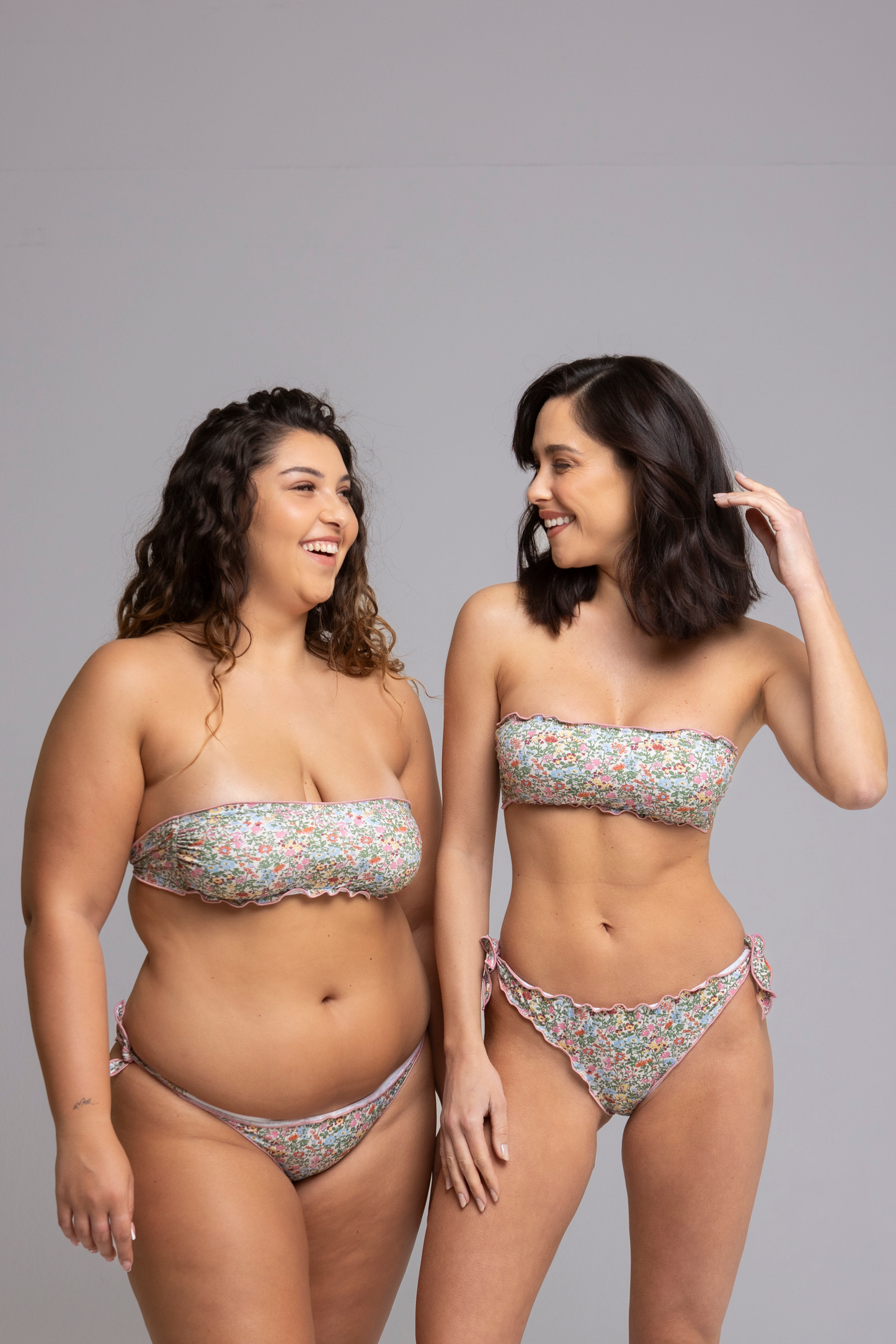 Two models wearing Fru Fru Pink Floral Fantasy Bandeau Bikini Set front view - one in size small, one in size large