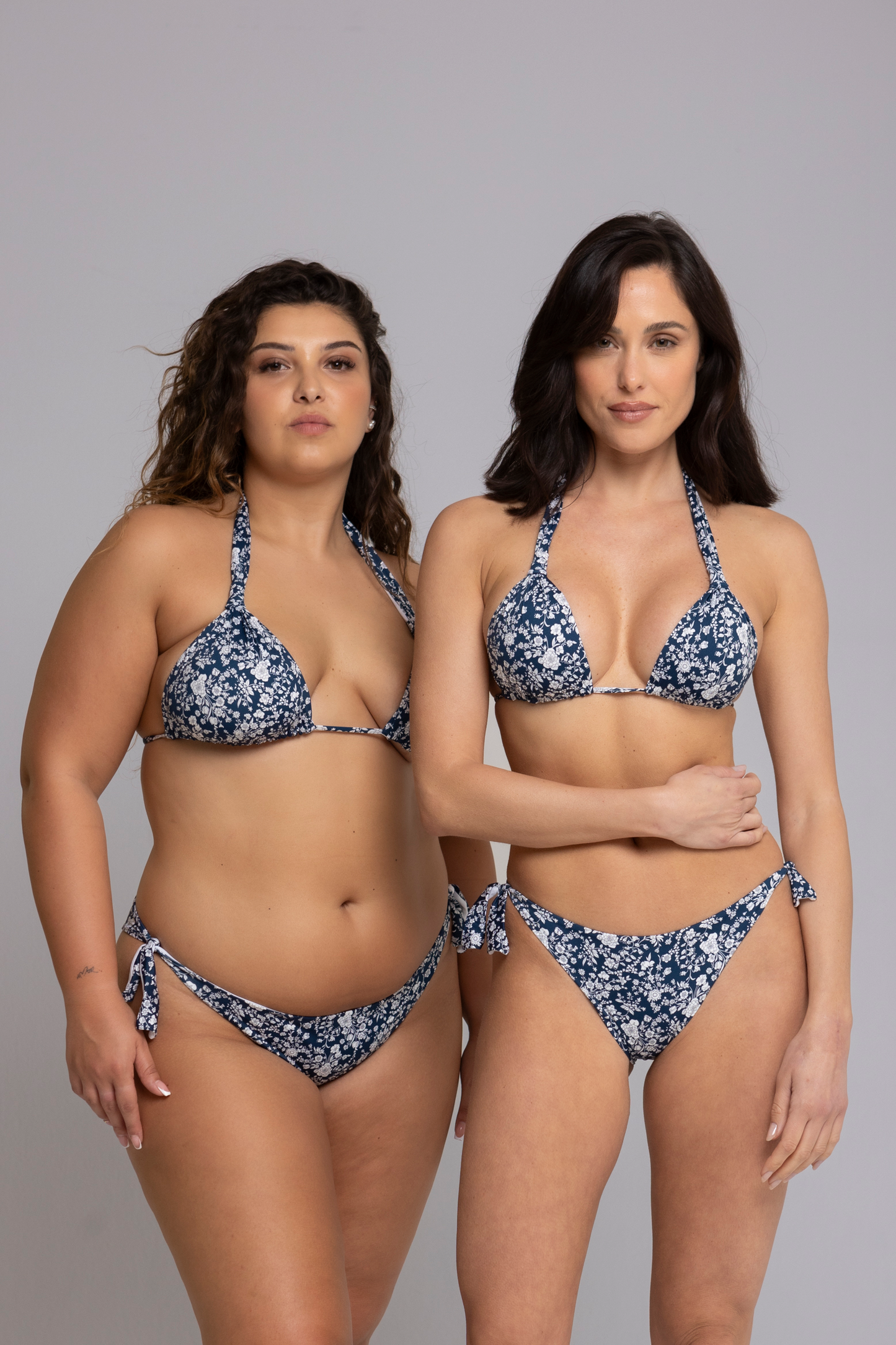 Two models wearing Floral Dark Blue and White Triangle Bikini Set front view — one in size small, one in size large.